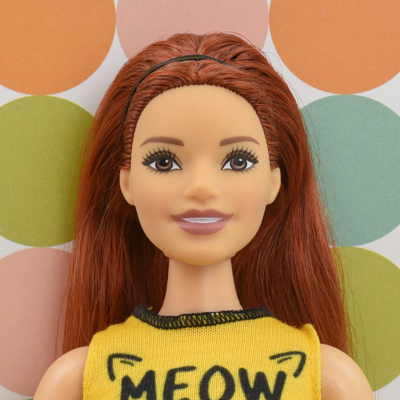 Headshot of a curvy Barbie doll with red hair named Erin