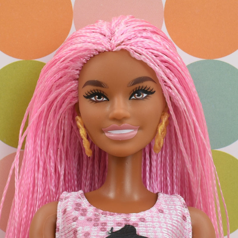 Headshot of a Barbie Extra doll with pink hair named Janelle